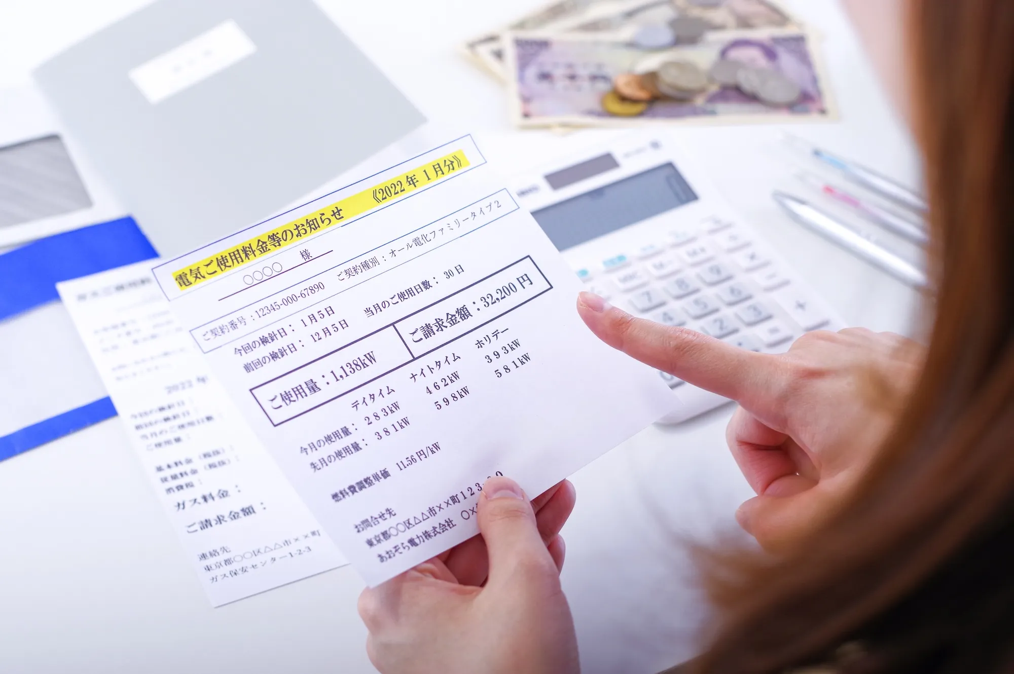 電気代の請求書を見つめる女性