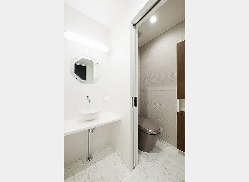 白のシンプルな洗面所とシックで高級感のあるトイレ