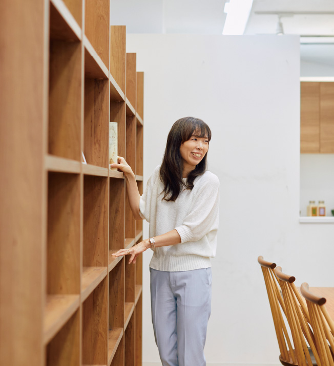 シェルフのそばに立つ近藤さん