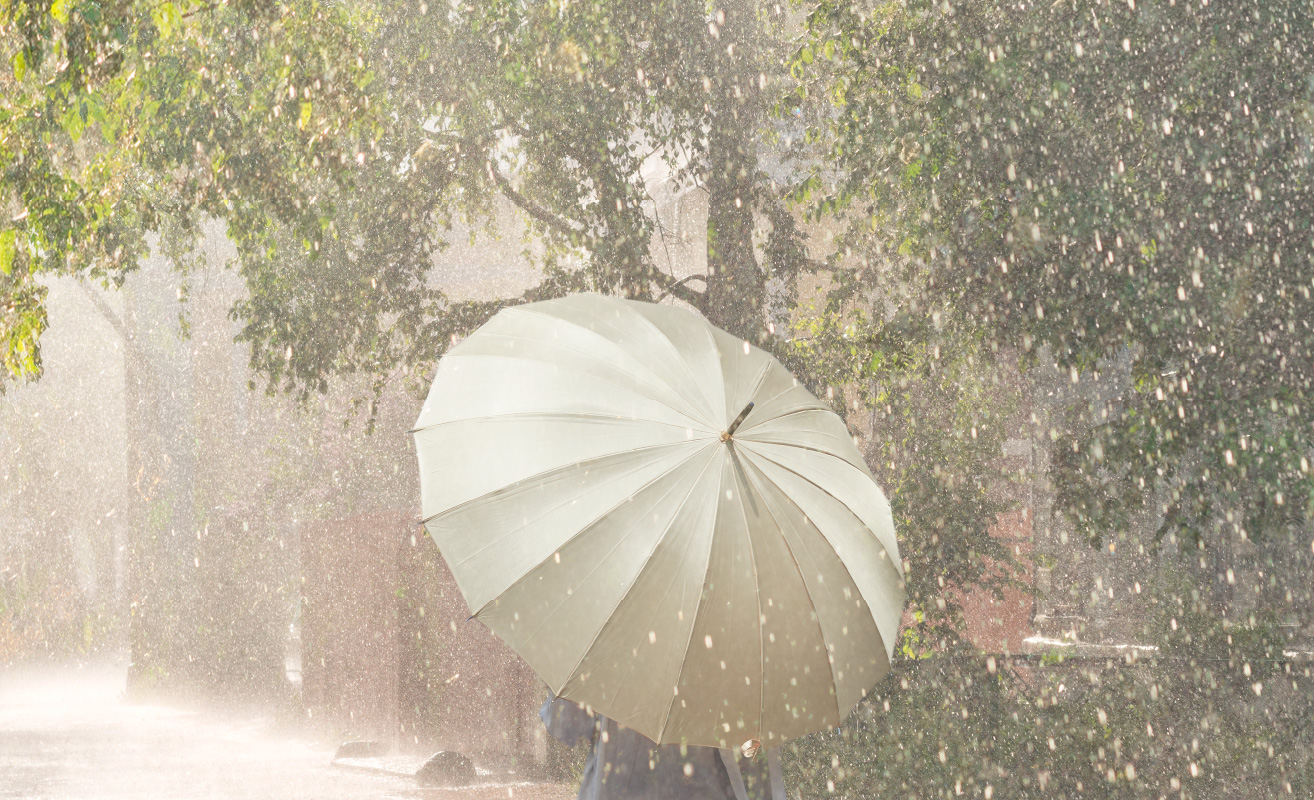 雨の中「前原光榮商店」の傘をさして歩く
