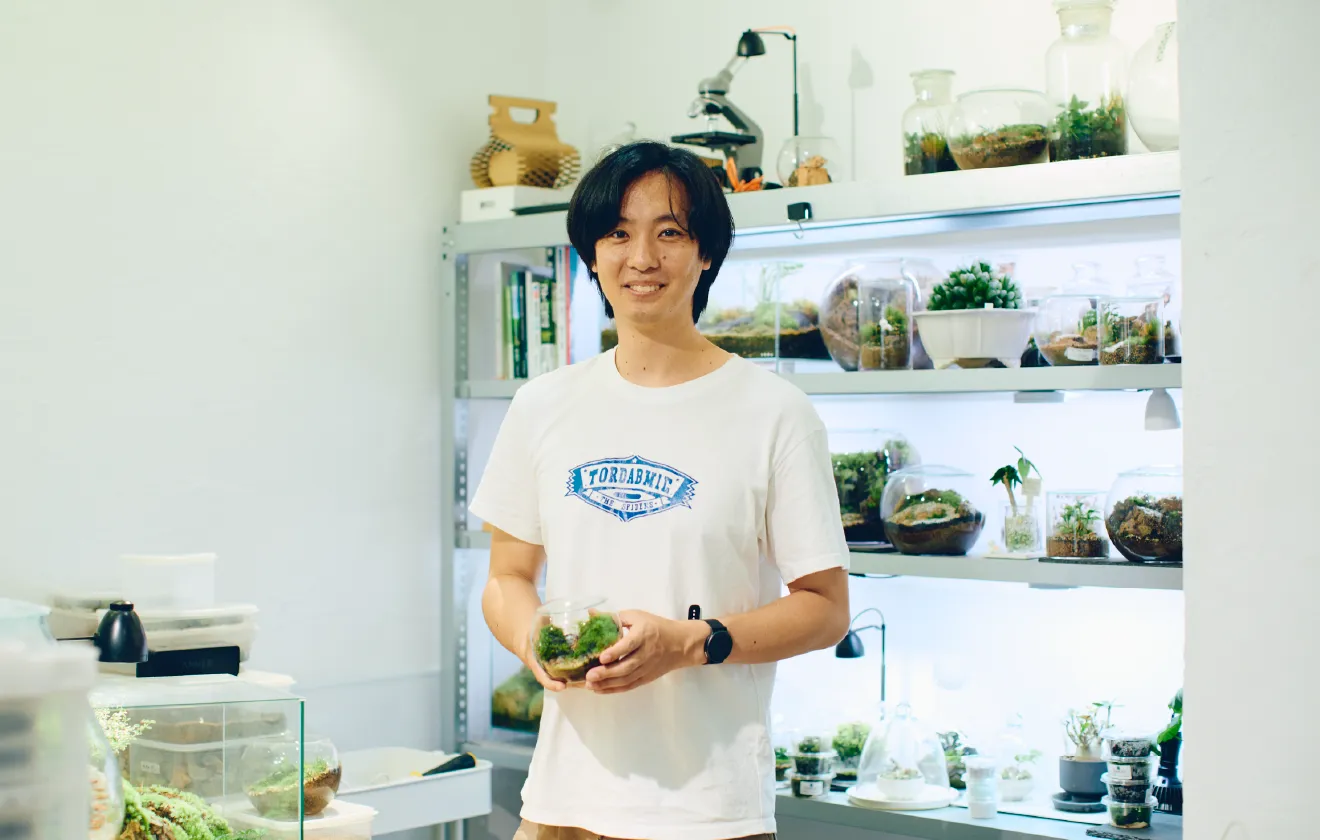 店内でテラリウムを手に微笑む店主