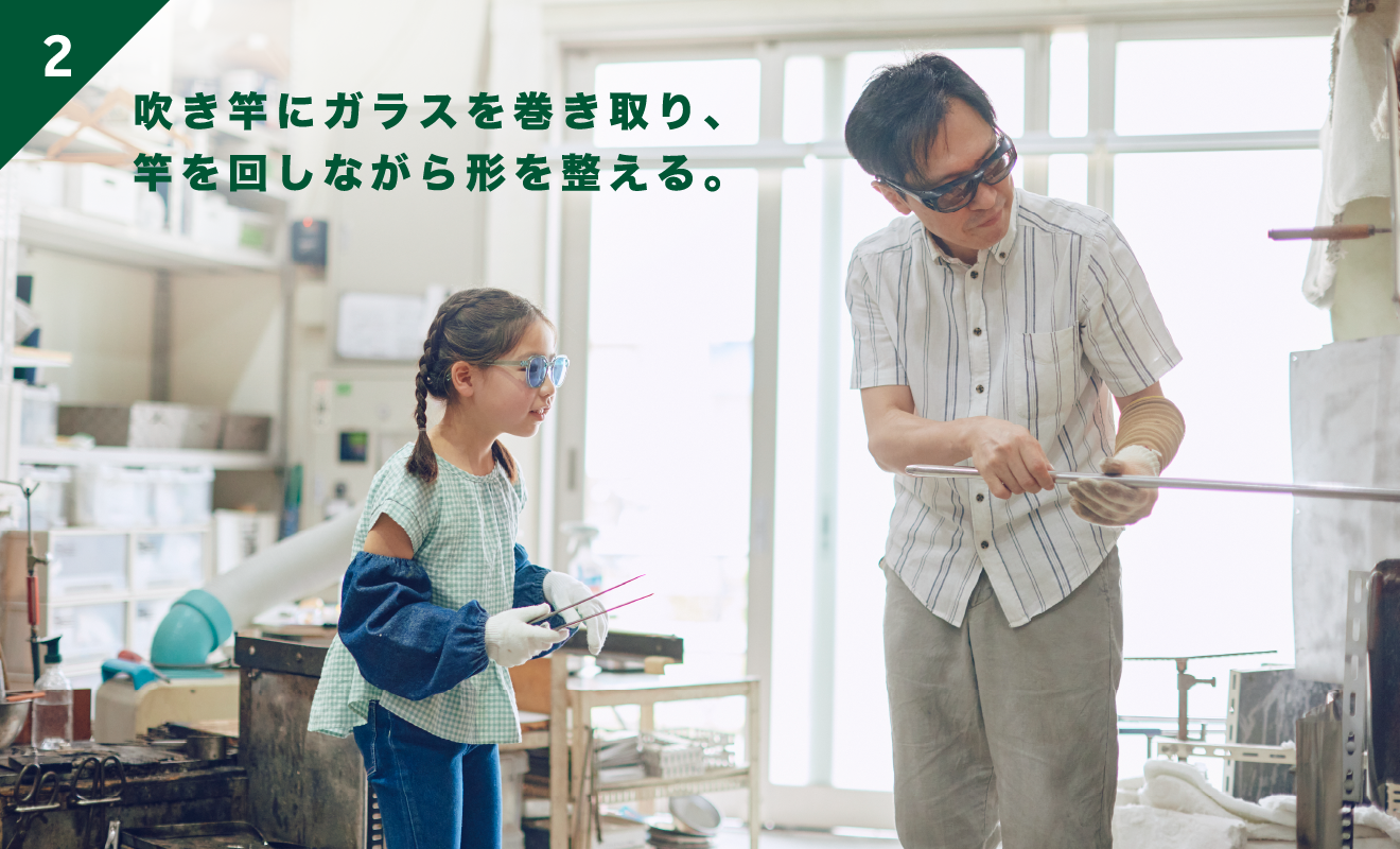 吹き竿にガラスを巻き取り、竿を回しながら形を整える。
